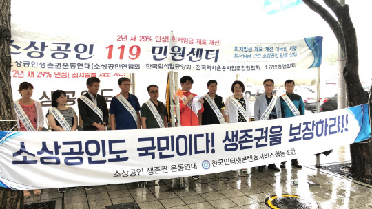 29일 서울 광화문에 설치된 '소상공인 119 민원센터'에서 최윤식 한국인터넷콘텐츠서비스협동조합 이사장이 최저임금 제도 개선을 촉구하는 성명서를 낭독하고 있다.<소상공인연합회 제공>